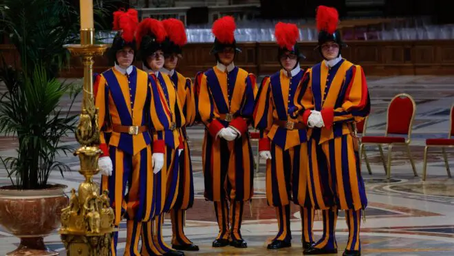 Guardas Suíços no Vaticano, com o uniforme tradicional vermelho, azul e amarelo.