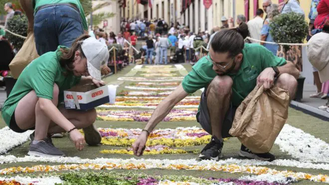 Católicos preparando a solenidade da decoração de tapetes para data de Corpus Christi.