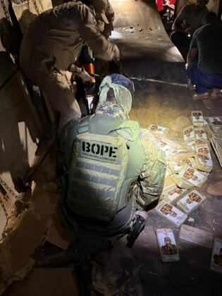 A carreta foi deslocada para esvaziamento de uma carga de soja e os policiais identificaram um fundo falso, que se estendia de fora a fora do reboque, onde foram encontrados 455 tabletes de substância análoga à pasta base de cocaína.