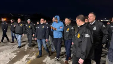 O ditador venezuelano, Nicolás Maduro (ao centro), é escoltado por agentes da Agência Antidrogas (DEA) neste sábado em Nova York (Estados Unidos). Maduro desembarcou algemado do avião militar Boeing 757 que o transportou para Nova York em meio a uma extensa operação de segurança.