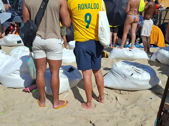 Ambulantes vendem sacos de areia a R$ 100 para servir de 'camarote' para o show da cantora Shakira em Copacabana